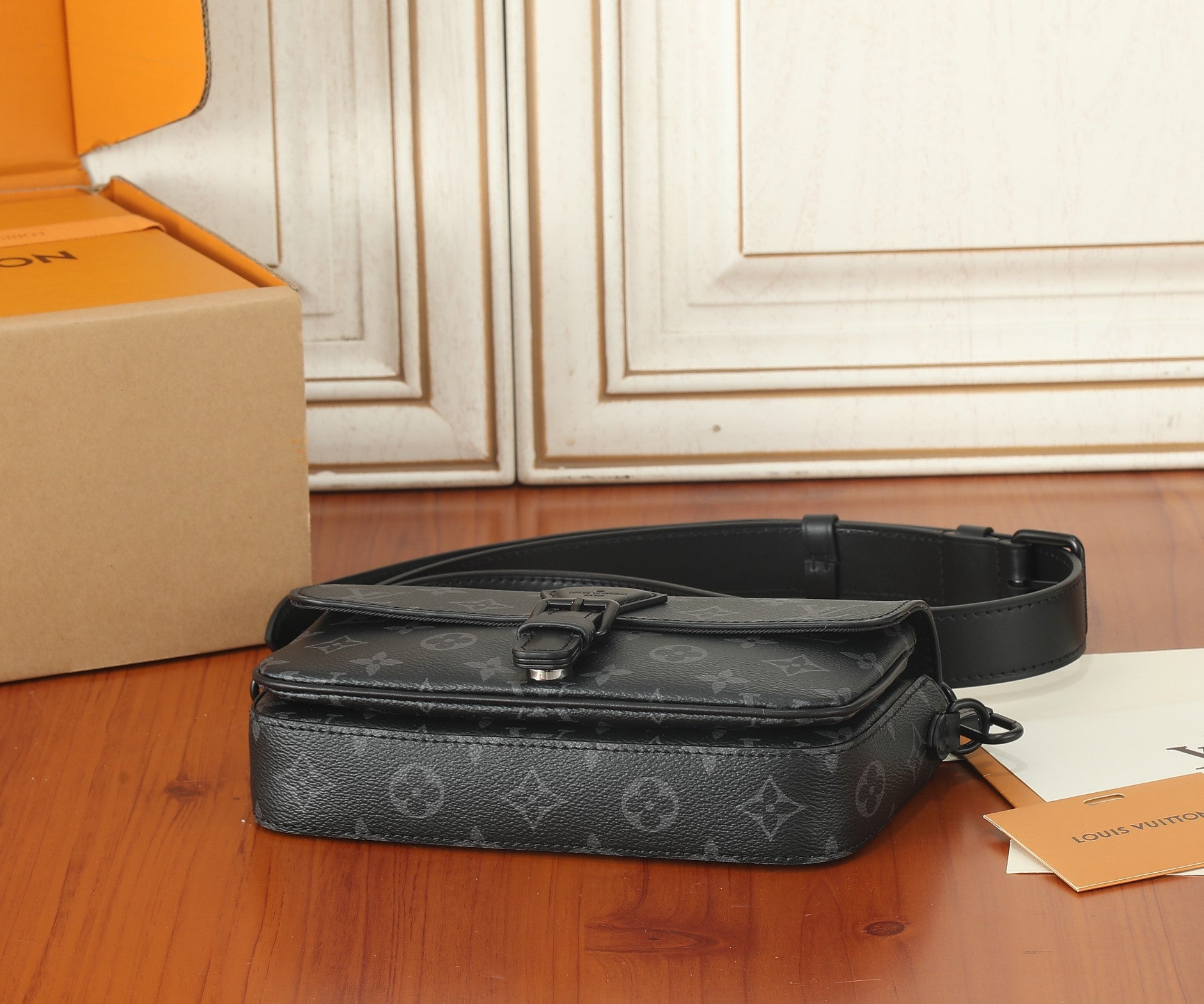 Louis Vuitton monogram crossbody bag with flap, buckle strap, and dark leather trim