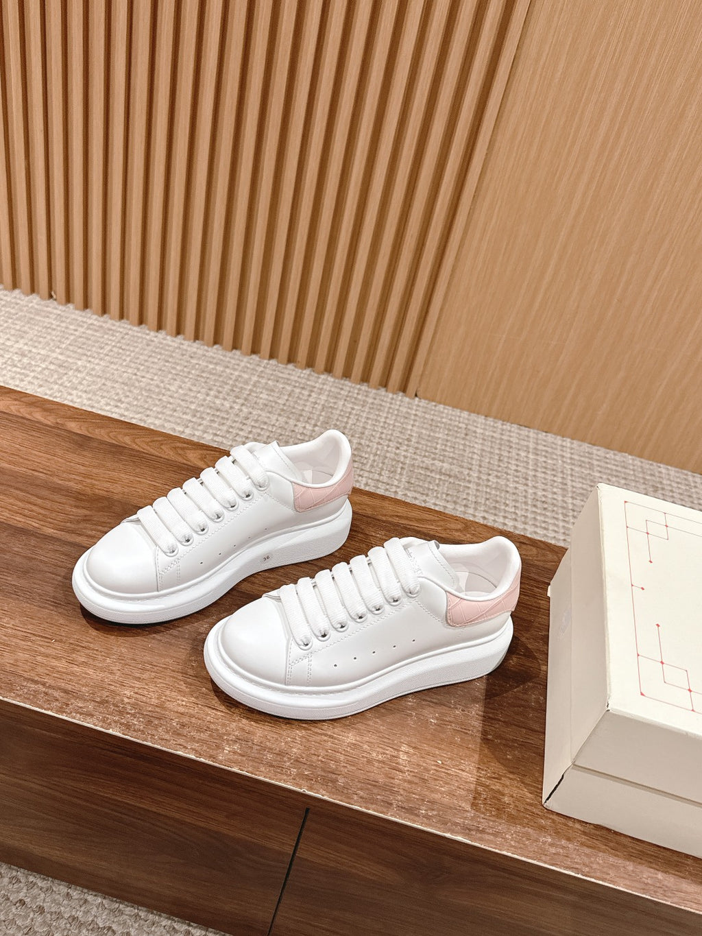 Pair of white leather low-top sneakers with lace-up closure