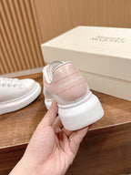 White leather sneaker with pale pink heel panel, lace-up