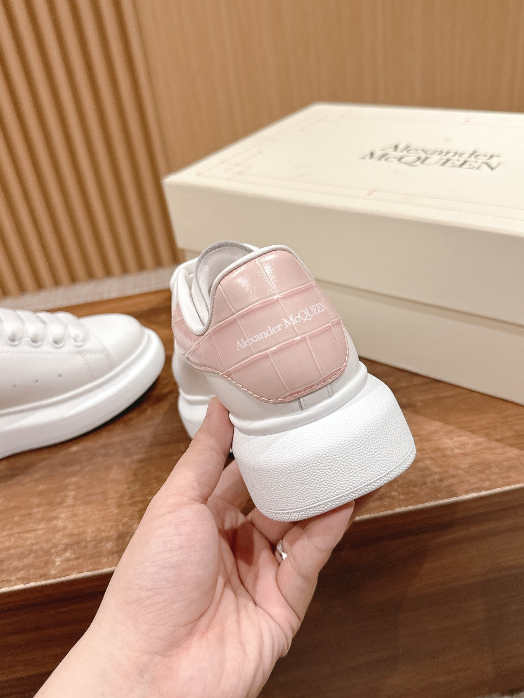 White leather sneaker with pale pink heel panel, lace-up