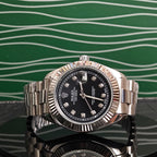 Rolex steel wristwatch with black dial, diamond markers, and linked bracelet
