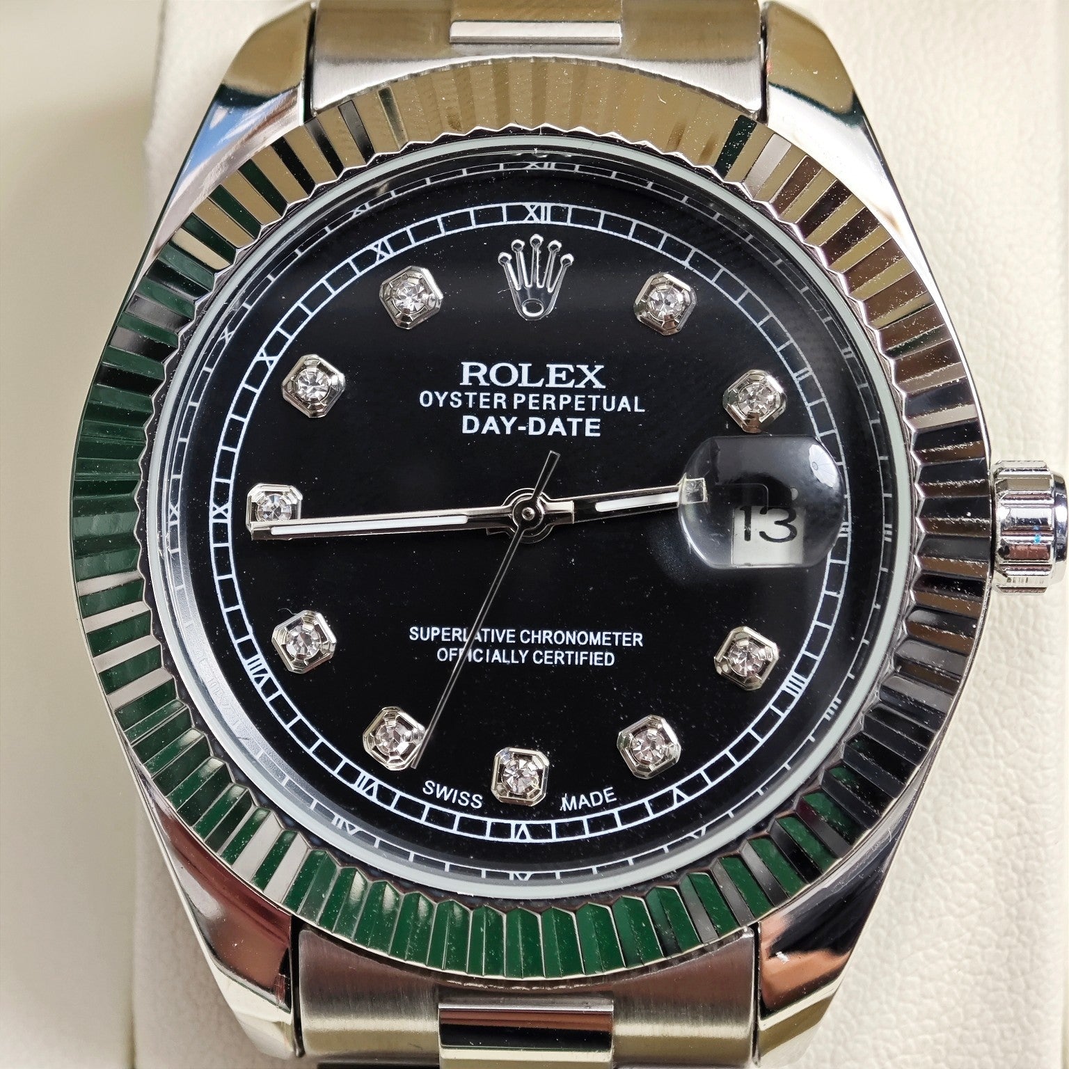 Rolex Day-Date watch face with black dial, diamond markers, and date window