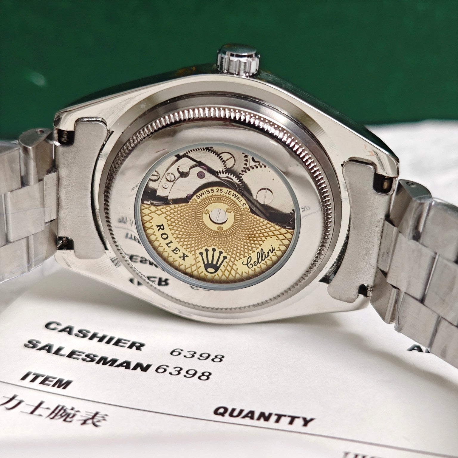 Rolex wristwatch case back close-up with crown and steel bracelet, on paperwork