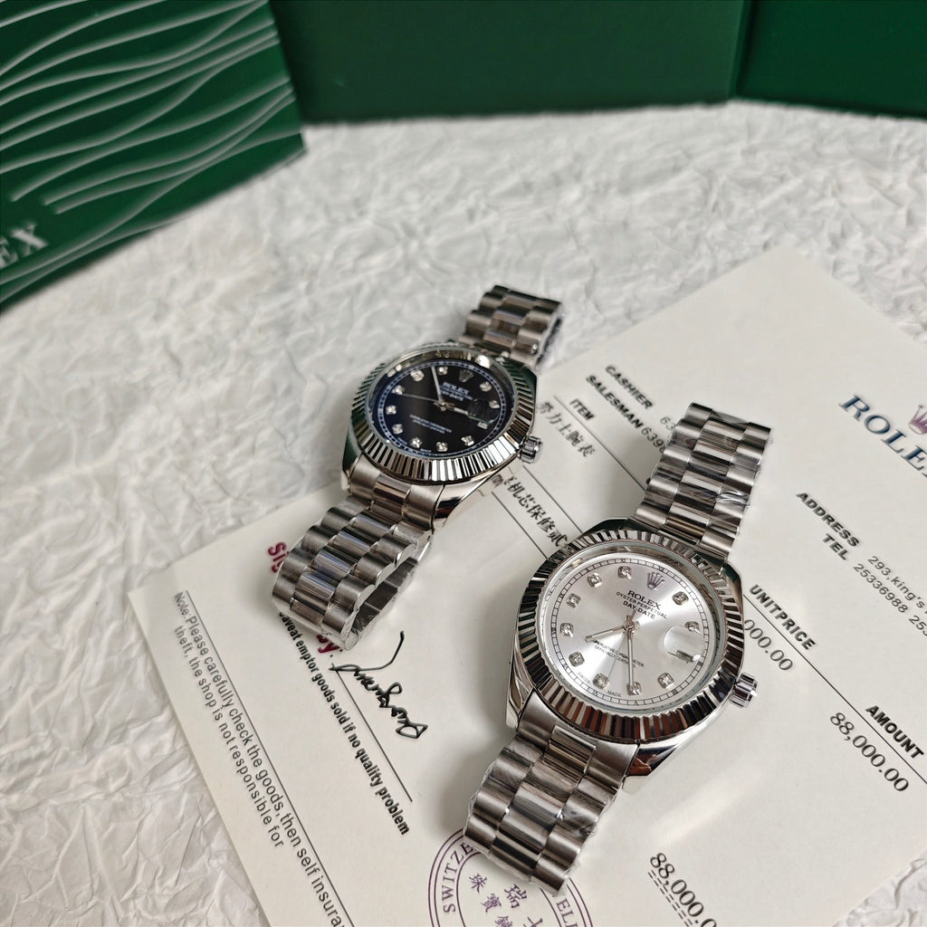 Rolex wristwatch pair on paperwork: dark dial watch and silver dial watch