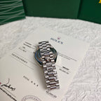 Rolex wristwatch and papers shown at angle, silver dial with steel bracelet