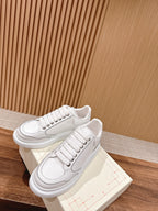 White lace-up sneakers with padded tongue and textured side seam