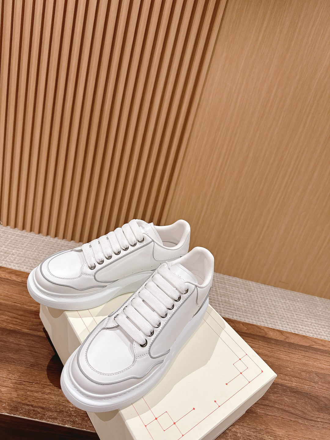 White lace-up sneakers with padded tongue and textured side seam