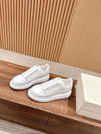 White lace-up sneakers with sculpted side panel and cushioned sole