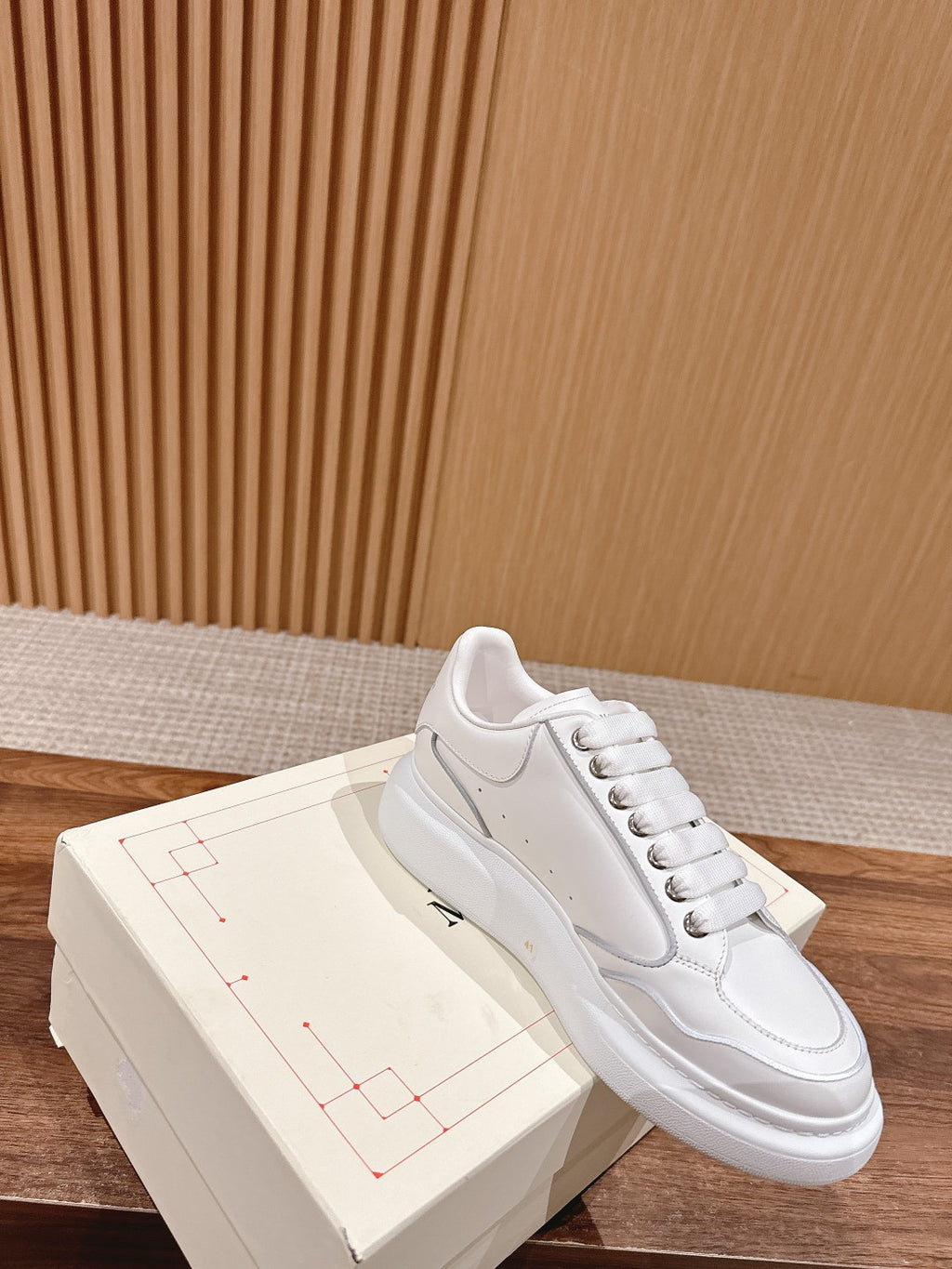 White lace-up low-top sneakers with signature side stripe and metal eyelets