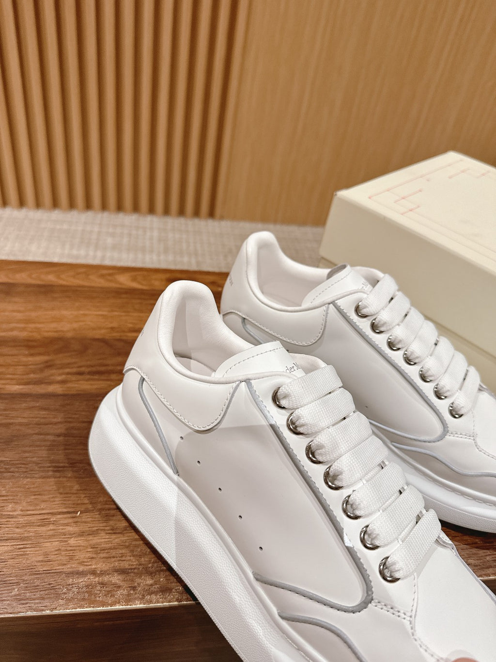 White leather lace-up sneakers with curved logo detail on the side