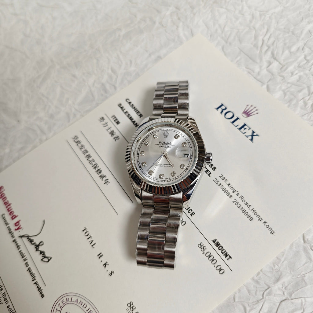 Rolex wristwatch on paperwork with silver dial and steel bracelet, side view