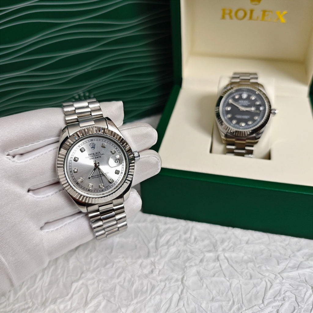 Rolex wristwatch with silver dial on stainless steel bracelet beside box and gloves