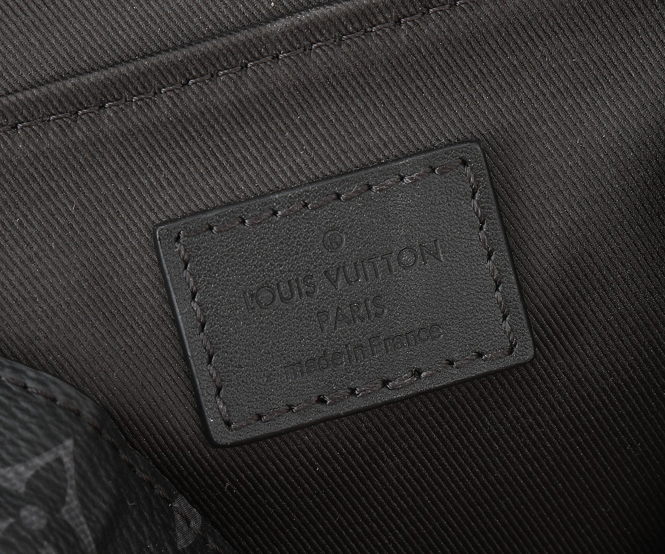 Louis Vuitton leather brand patch on black fabric lining with stitched border