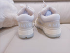 Light beige sneakers with white laces and AMIR heel logo, rear view