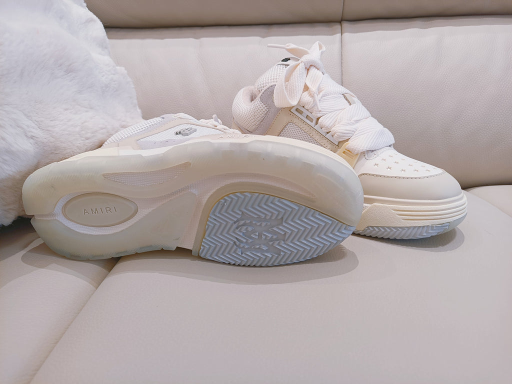 Sneakers showing white rubber outsole with blue-gray herringbone tread