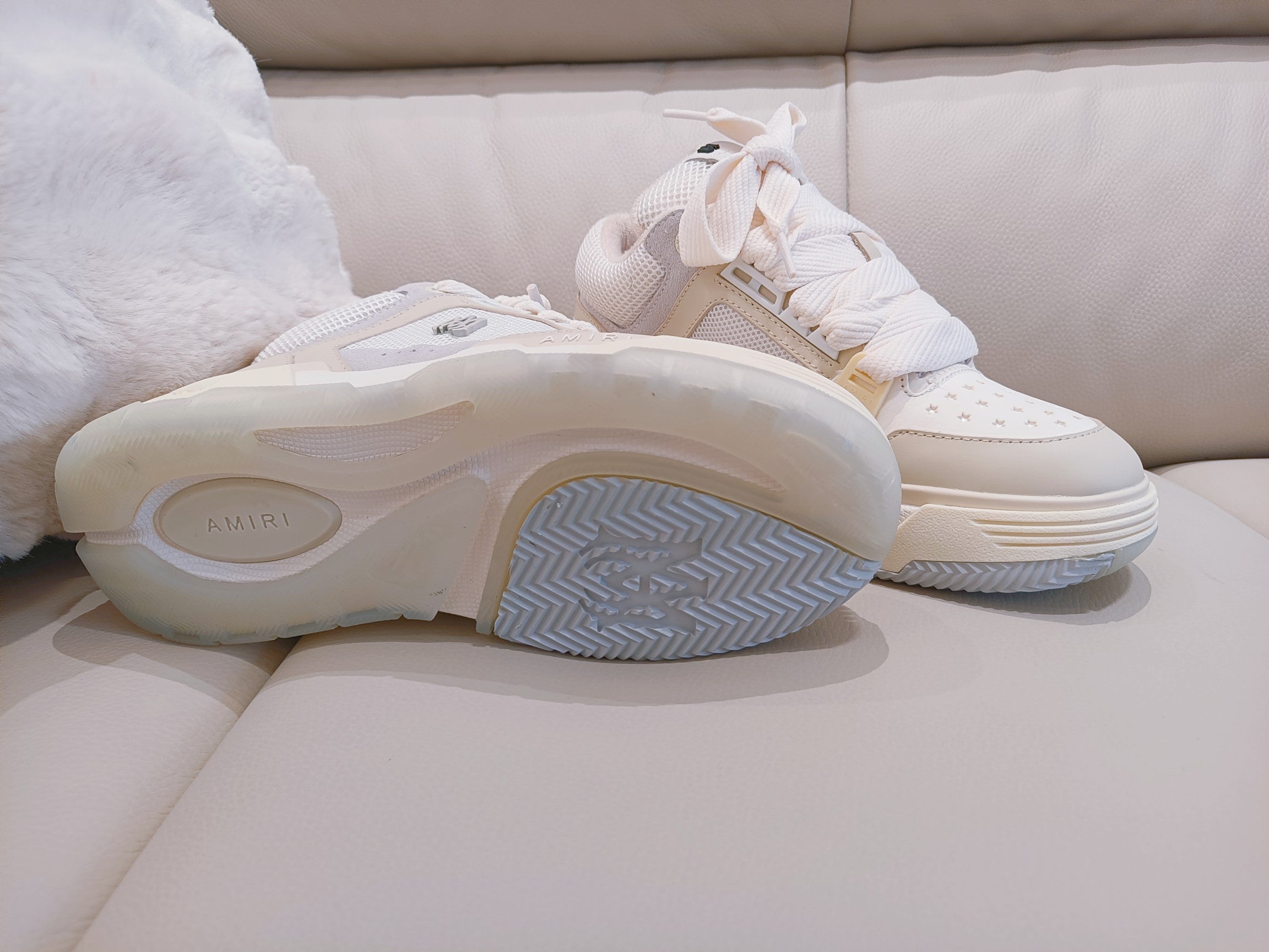 Sneakers showing white rubber outsole with blue-gray herringbone tread