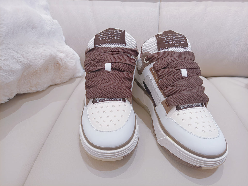 Pair of white low-top sneakers with brown knit tongues and laces