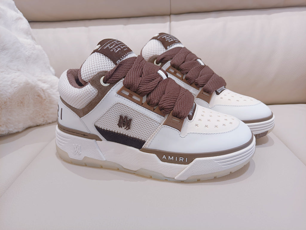 White low-top sneakers with brown laces and dark side stripe, logo accents