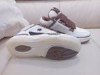 White low-top sneakers with brown laces, sole and tread visible from side
