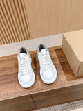 Alexander McQueen white low-top sneakers with gray heel and lace-up front