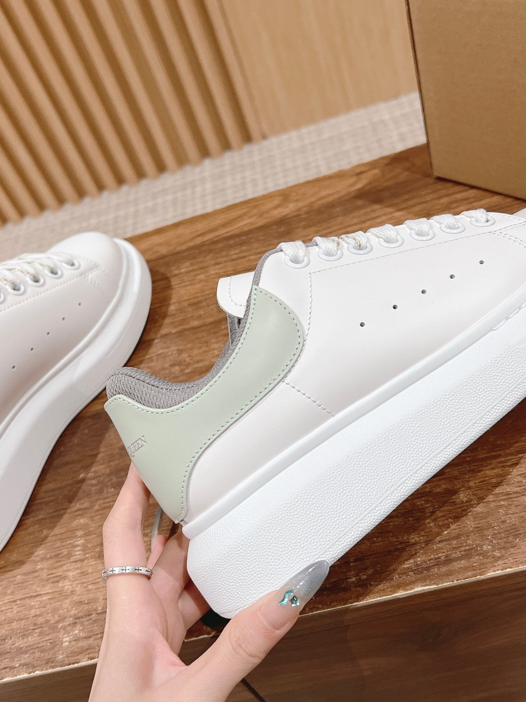 Alexander McQueen sneaker side panel detail in white with gray trim and eyelets