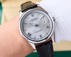 Rolex Datejust watch on wrist, silver dial with Roman numerals, black leather strap