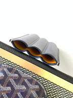 Small Goyard patterned pouch bag showing navy leather pocket and open organizer