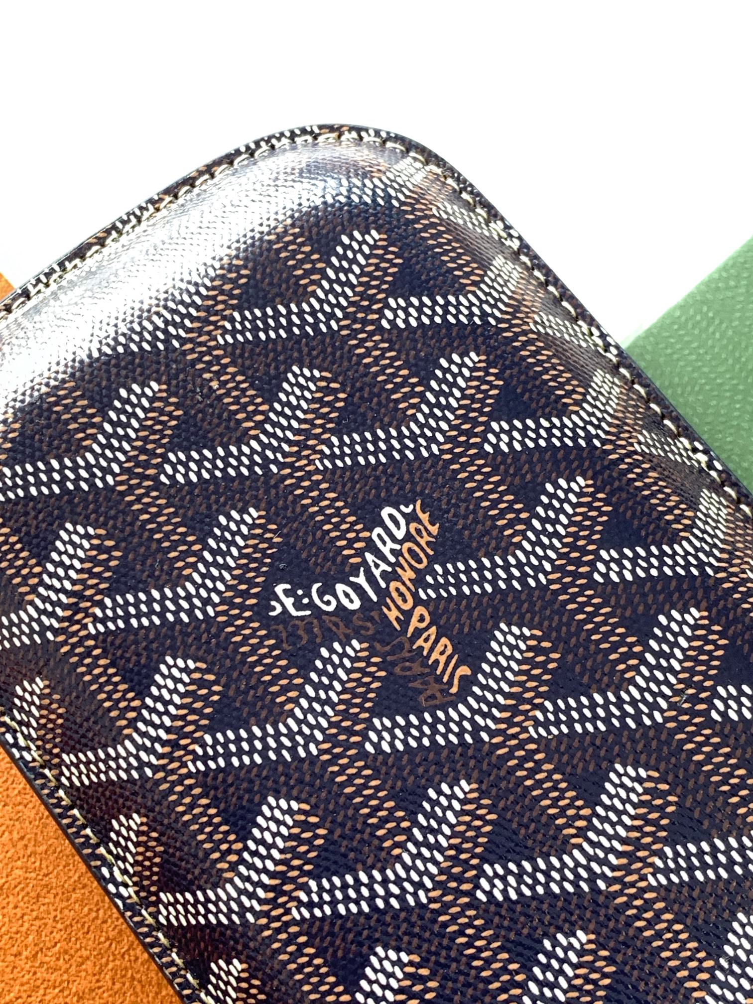 Small Goyard patterned pouch bag close-up with stitched edges and logo on the front