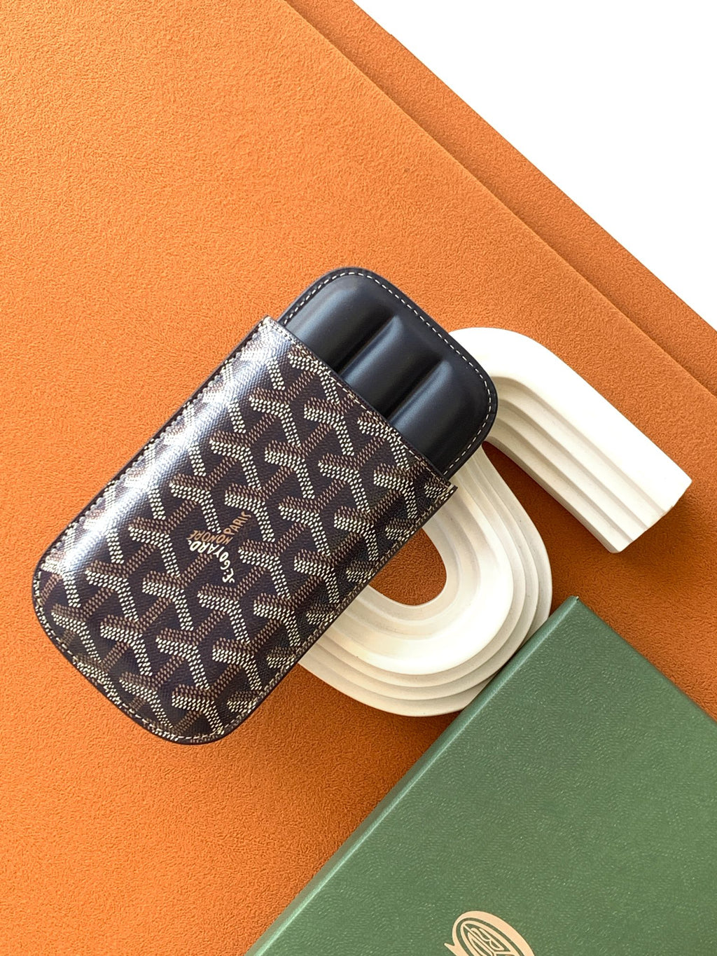 Small Goyard patterned pouch bag with navy leather trim and white candle holders inside