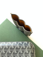 Small Goyard mini bag open to show interior compartments and brown lining