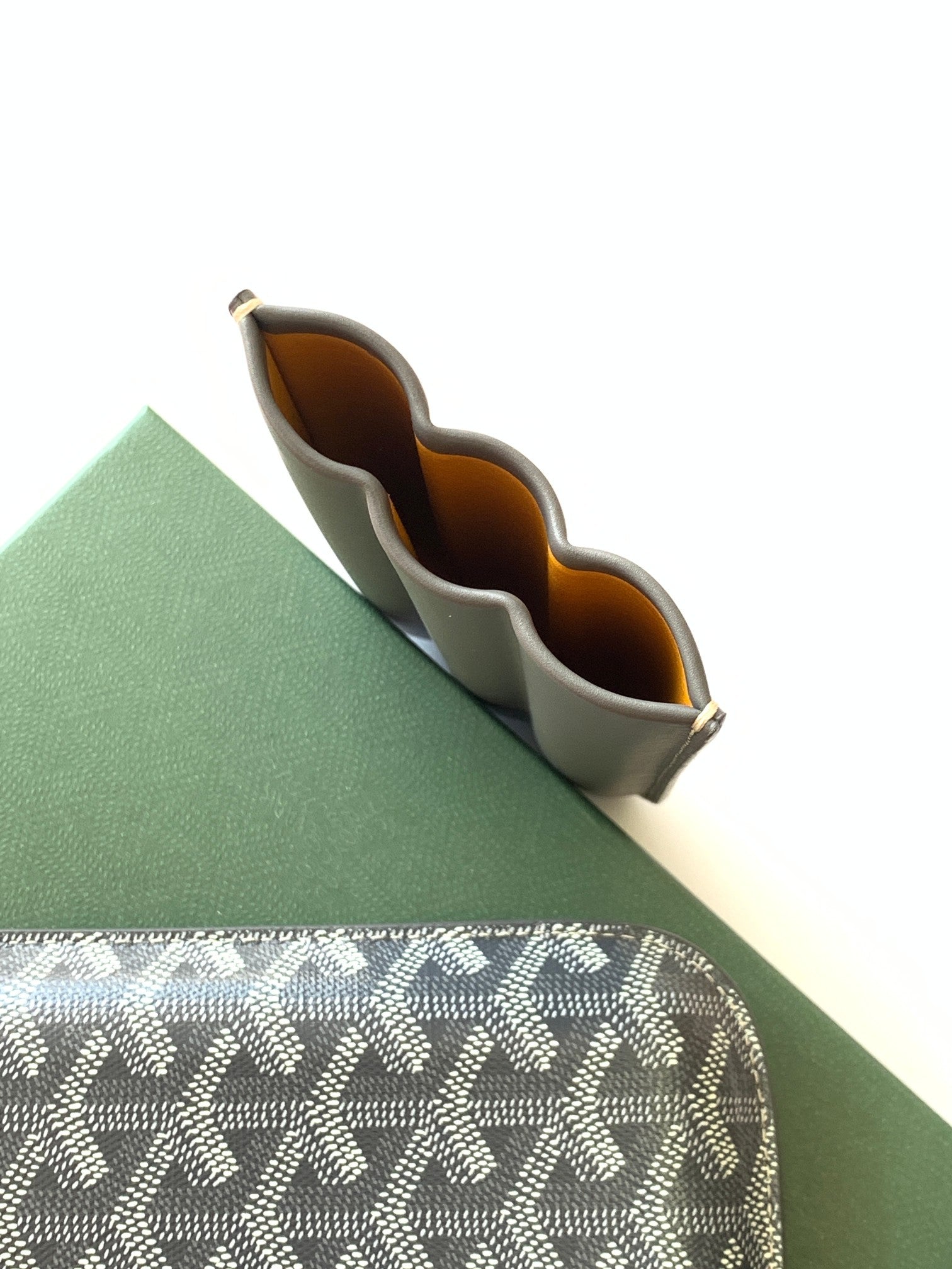 Small Goyard mini bag open to show interior compartments and brown lining