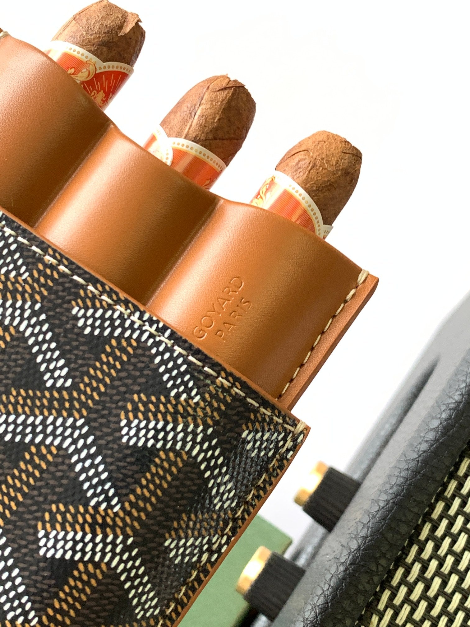 Goyard canvas bag detail with tan leather interior pockets and Goyardine patterned exterior