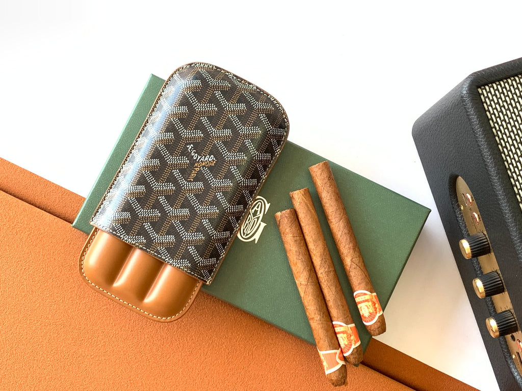 Goyard canvas bag with Goyardine pattern and tan leather slots, shown beside textured pouch