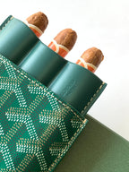 Goyard green patterned card holder holding rolled accessories in slots