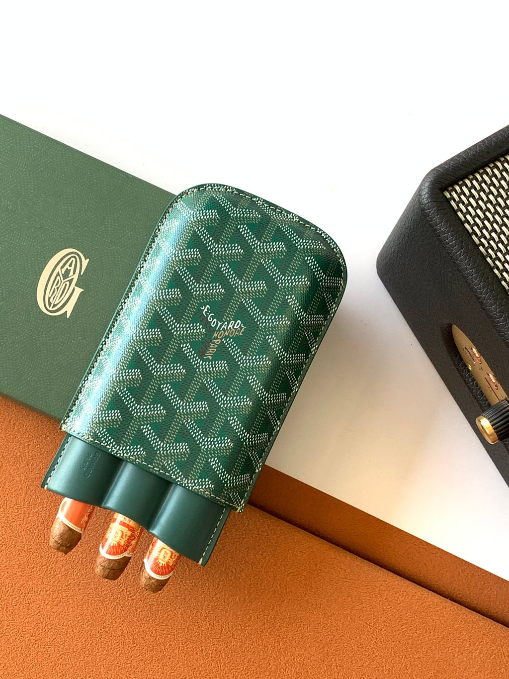 Goyard green patterned card holder with open top and rolled items inside