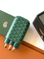 Goyard green patterned card holder with open top and rolled items inside