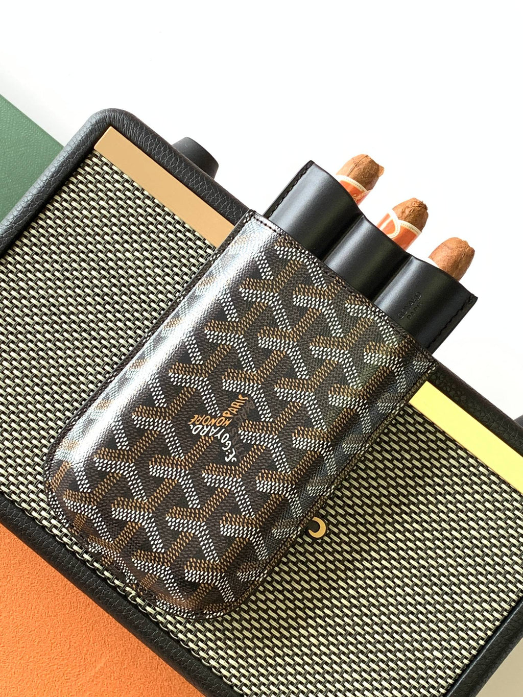 Goyard patterned bag on holder with multiple slots and black leather strap handle