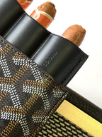 Goyard patterned bag with black leather flap and stamped text near edge