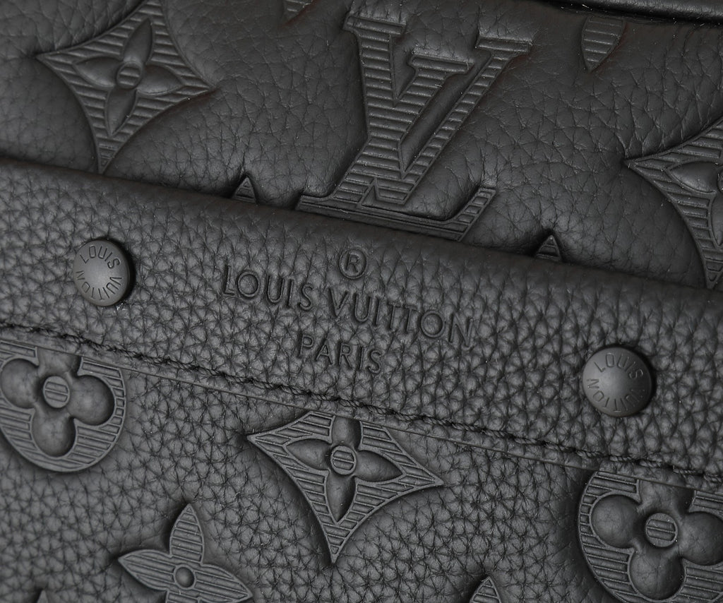 Crossbody bag front panel detail with embossed logo motifs and quilted texture