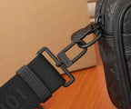 Crossbody bag strap detail with black webbing and metal D-ring hardware