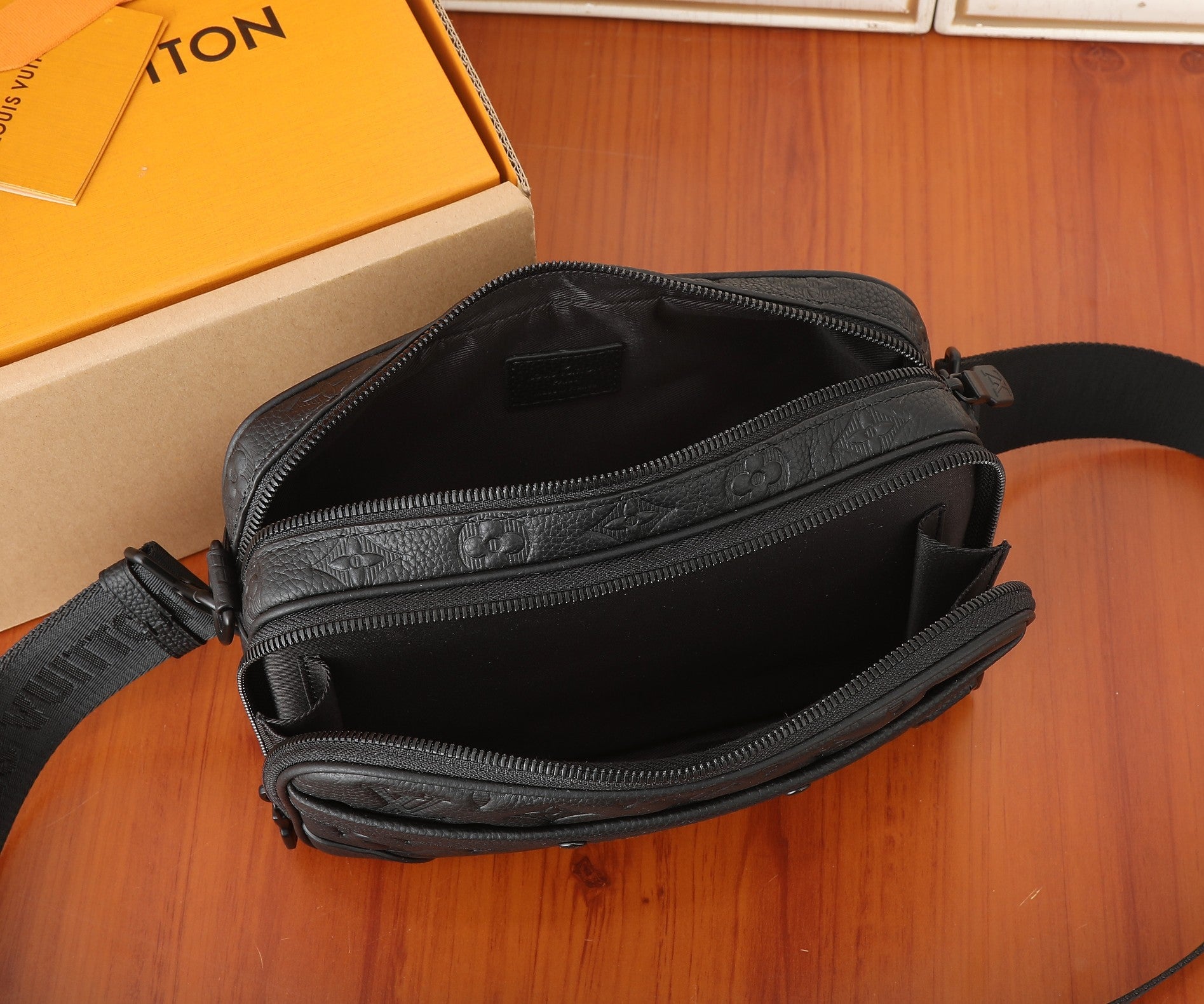 Crossbody bag open top with dark interior and zipper track, adjustable strap