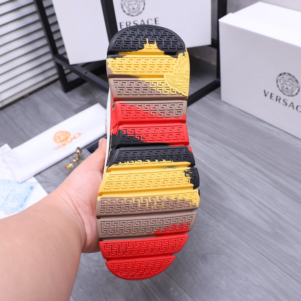 Luxury sneaker outsole view with multicolor tread: gold, navy, and red steps