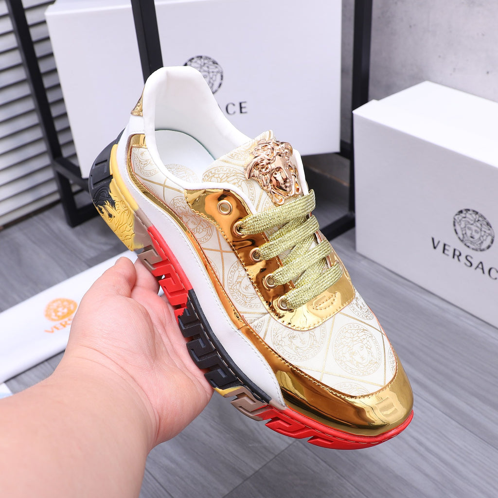 Luxury sneakers held in hand, white and gold upper, green laces, red/black sole details