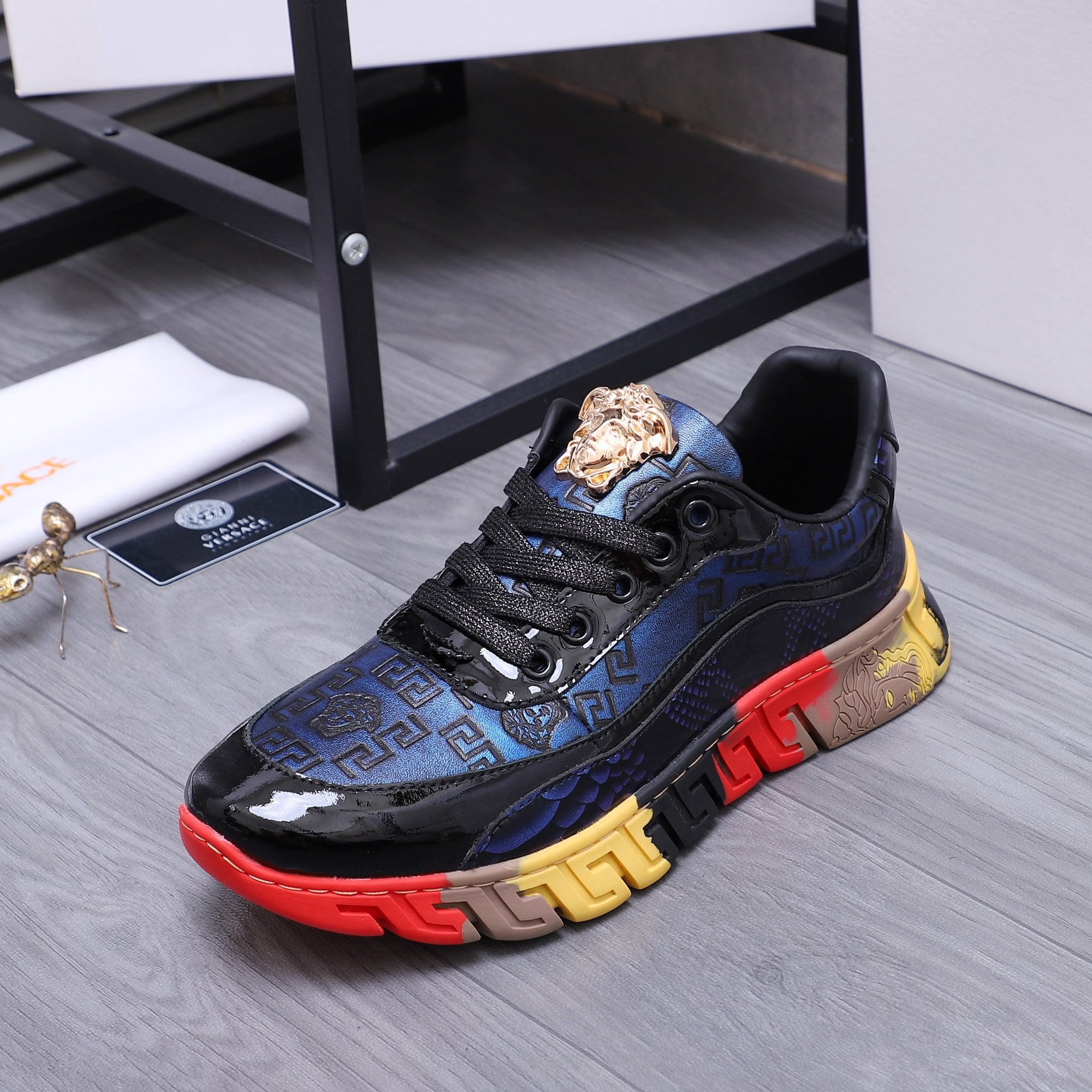 Low-top athletic sneakers, black and blue upper with gold lion crest and chunky sole