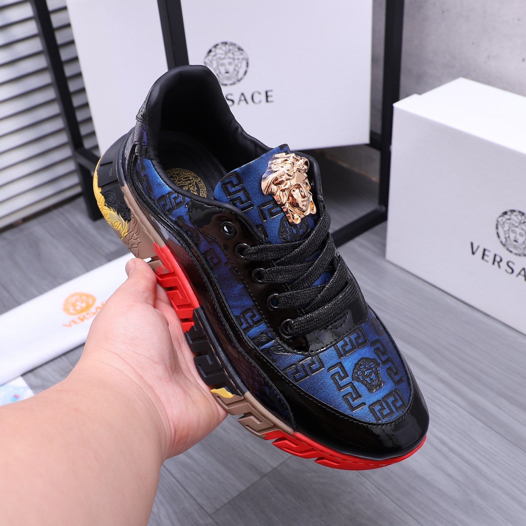 Low-top athletic sneakers, black and blue with gold lion logo and red sole detail