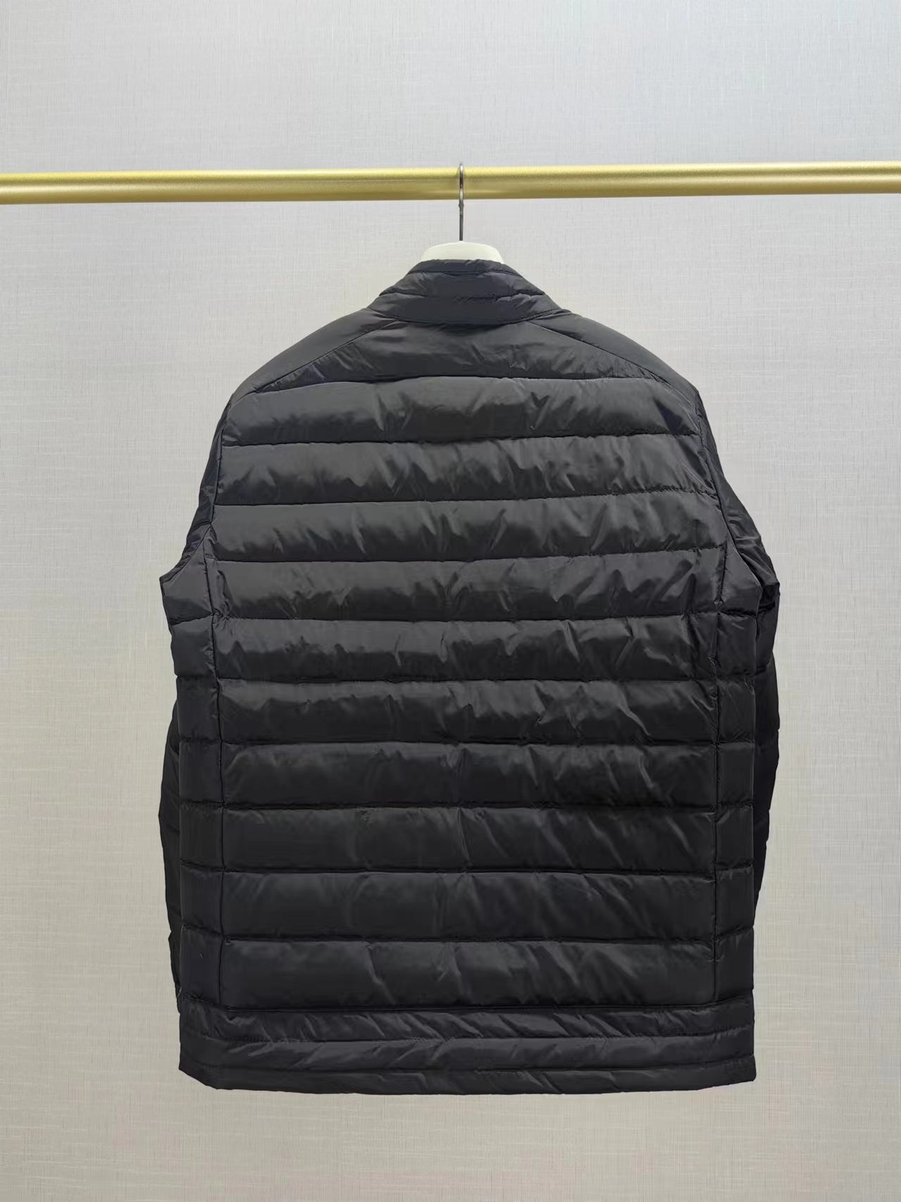 Moncler long dark puffer jacket back view with horizontal quilted panels