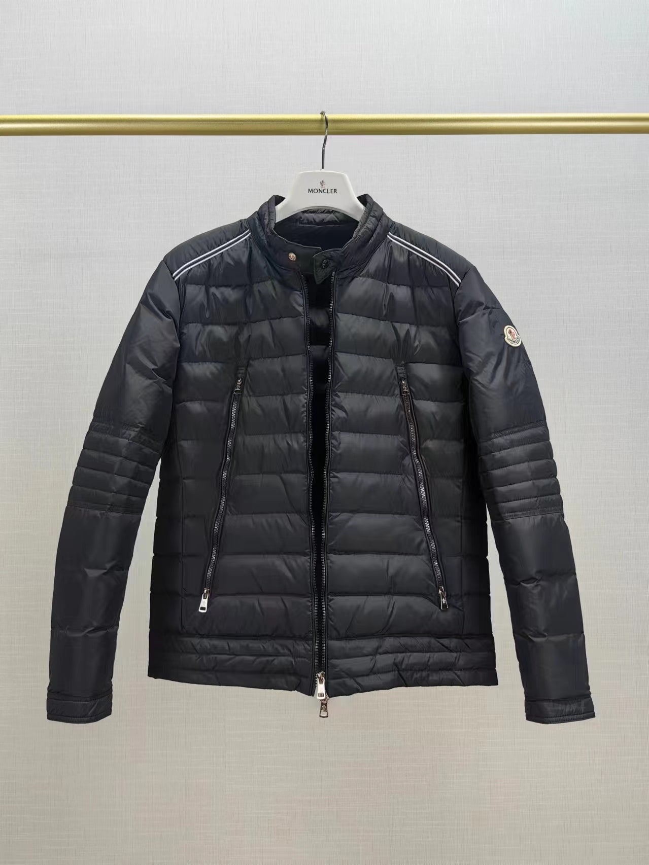 Moncler long dark puffer jacket front view with stand collar and zip