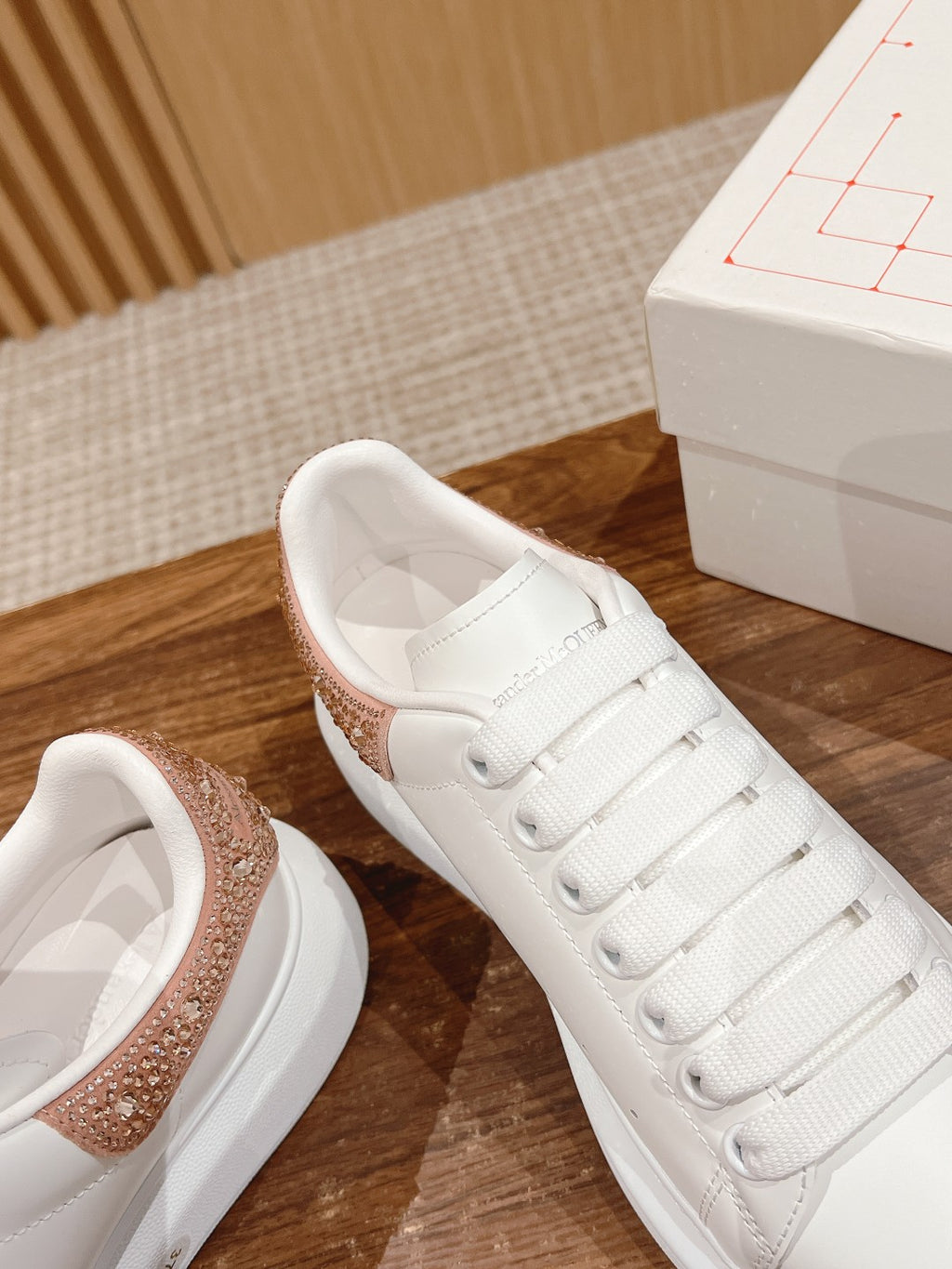 White leather sneaker with rose-gold glitter collar and lace-up eyelets, close-up