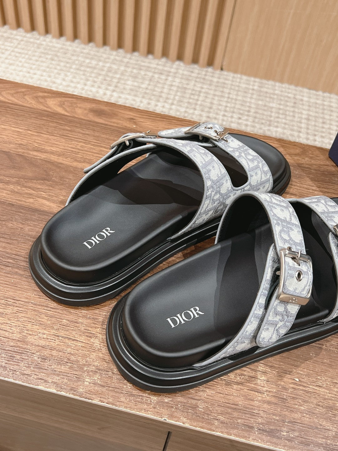 Dior slide sandals, angled view; black insole with Dior text and monogram straps