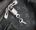 Black monogram bag hardware: silver zipper pulls and D-ring key holder charm.